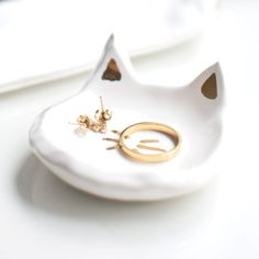 a pair of gold rings sitting on top of a white plate