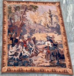 an old tapestry hanging on the side of a building with horses and people in it