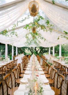 an outdoor tent with tables and chairs set for dinner