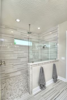 a bathroom with a walk in shower next to a bathtub and two towels hanging on the wall