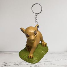 a keychain shaped like a cat sitting on top of a rock