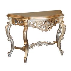 a gold and silver console table with ornate carvings on the top, sitting against a white background