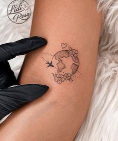 a woman's arm with a tattoo on it that has the earth and birds flying around