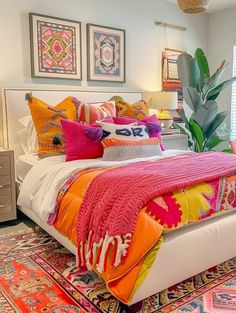 a bed with colorful pillows and blankets on top of it