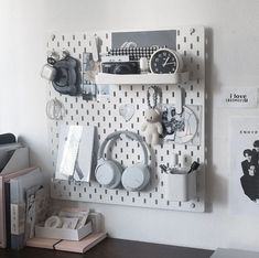 a wall mounted shelf with headphones, books and other items on top of it