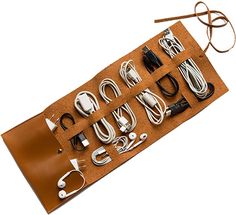 an assortment of electronic devices are laid out on a brown leather case with cords and plugs