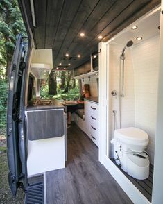 a woman sitting in the back of a camper van with her feet on the toilet