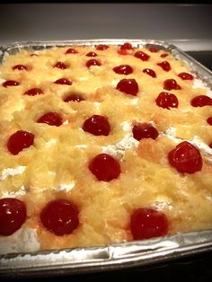 a pizza with pineapples and cherries on it sitting on a stove top