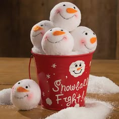 some snowmen are sitting in a red bucket