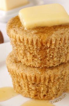 two cupcakes with butter on top are sitting on a plate next to each other