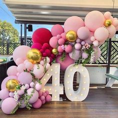 balloons and greenery decorate the number ten sign