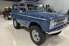 an old blue pickup truck parked in a garage