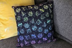 a couch with three pillows on top of it and one has an image of the same pattern