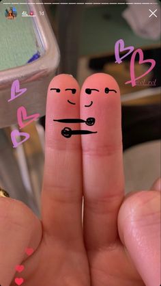 two fingers with faces drawn on them