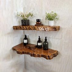 two wooden shelves with bottles and vases on them in the corner of a bathroom