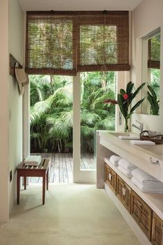 a bathroom with large windows and wooden flooring