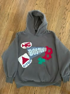 a gray hoodie with an image of a rocket ship on it