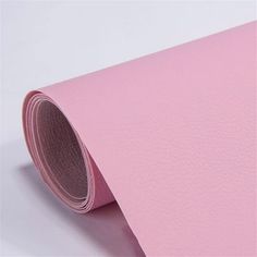 a roll of pink paper sitting on top of a white table