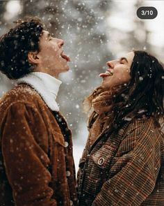 two people standing in the snow with their mouths open