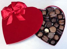 a red heart shaped box filled with chocolates