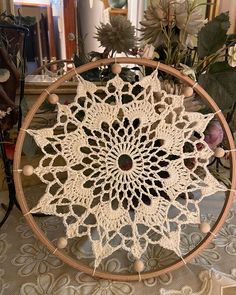 a crocheted doily sitting on top of a table next to some flowers