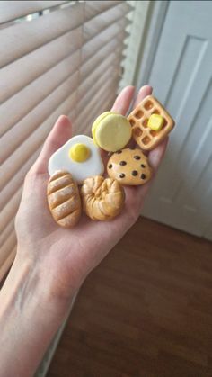 a person holding some food items in their hand with the blinds closed behind them,