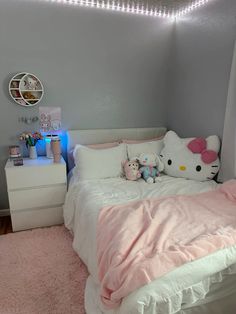 a bedroom with hello kitty bedding and pink rugs on the floor next to a white dresser