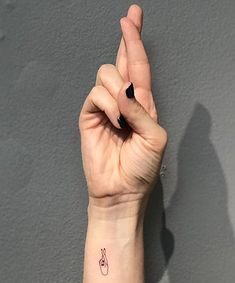 a woman's hand with a small tattoo on her left wrist and the word love written in it