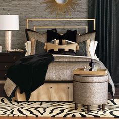 a bedroom with a large bed covered in black and gold pillows