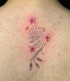 the back of a woman's neck with pink flowers and a bird on it