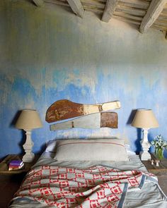 a bed in a room with blue walls and two lamps