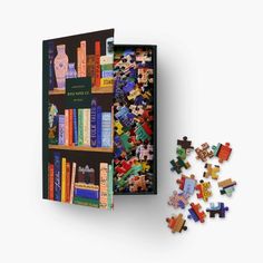 an open book with colorful books on it next to a pile of puzzles that have been placed in front of it