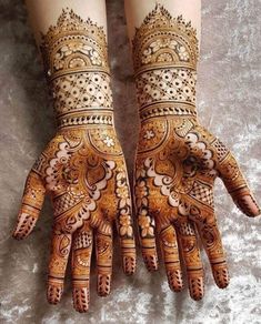 two hands with henna designs on them