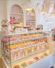 a bakery filled with lots of different types of cakes and cupcakes on display