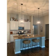 a kitchen with two bar stools next to an island