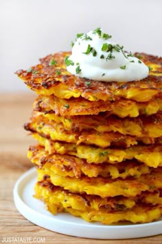 a stack of potato pancakes with sour cream on top