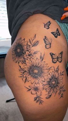 a woman's thigh with sunflowers and butterflies on it