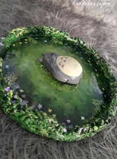 a bird sitting on top of a green plate covered in leaves and flowers with the word love written on it