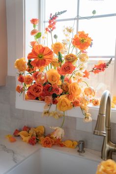 a gold and orange floral installation by WildFlora in Los Angeles in a pink kitchen with a white sink. flowers spill out of the sink and bloom in the window sill. Orange Spray Rose, Iceland Poppy, Orange Ranunculus, Ranunculus Bouquet, Parrot Tulip, Poppy Bouquet, Orange Star, Orange Bouquets, Orange Wedding Flowers