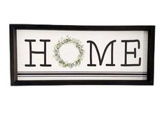 a framed sign with the word home painted on it and a wreath in the middle