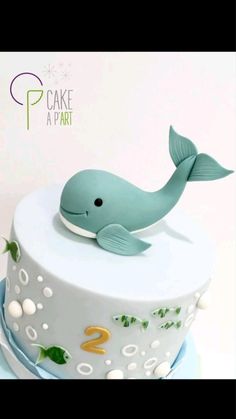 a blue cake with a whale on it's top and the number two is 2