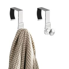 two towels hanging from hooks on the wall next to a towel rack with black handles