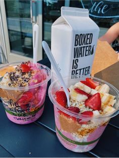 two plastic cups filled with ice cream and strawberries