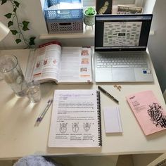 an open laptop computer sitting on top of a white desk