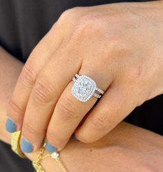 a close up of a person's hand with a diamond ring on their finger