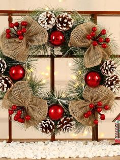 a christmas wreath with pine cones, red balls and burlucks on it