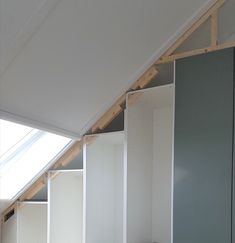 an attic with white walls and shelving in it