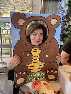 a woman holding up a teddy bear cutout with the words mateo's birthday written on it