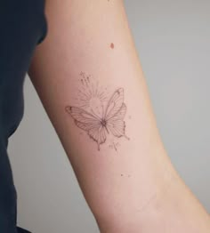 a woman's arm with a butterfly tattoo on the left side of her arm