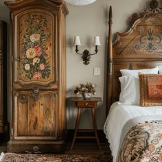 a bed room with a neatly made bed next to a tall wooden cabinet and two lamps